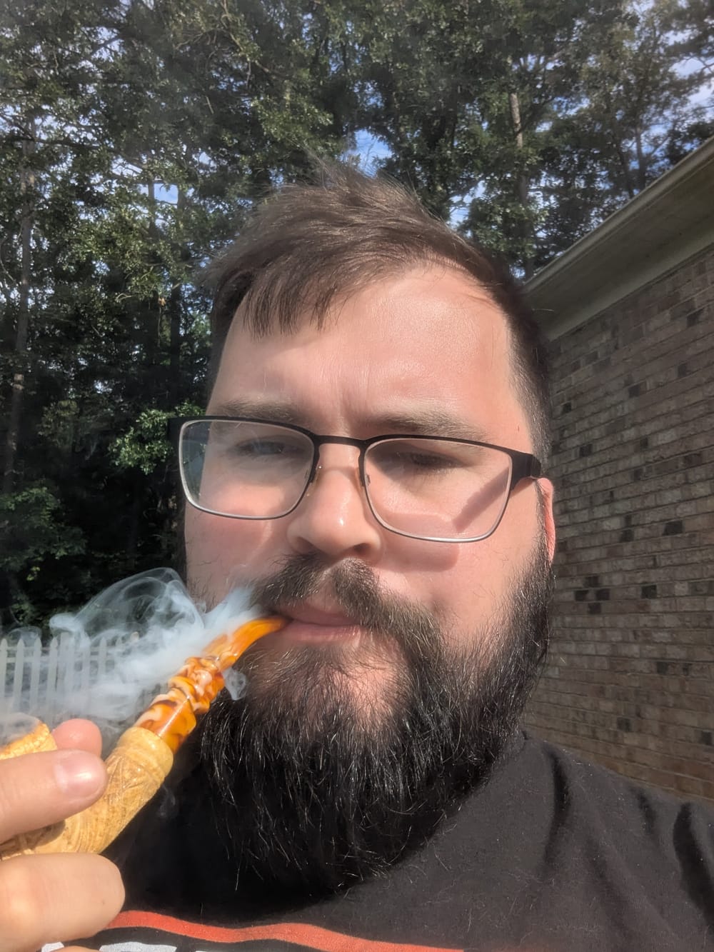 Remy Sheppard smoking a pipe outdoors