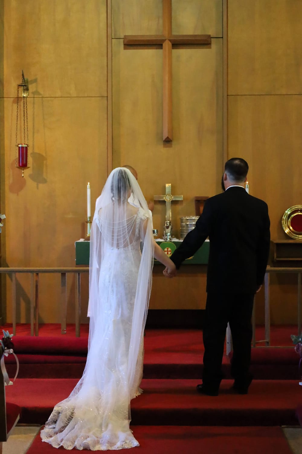 Remy Sheppard holding his wife's hand at the altar during their wedding ceremony